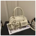 Detail of cream white leather Boston bag with pearl bow and silver hardware on a magazine - White