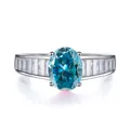 Détail macro de la bague moissanite bleue ovale avec pierres baguette sur anneau argent - Bleu glacier