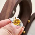 Detailed view of 3-carat yellow moissanite ring with pear-shaped side stones in silver setting - US 5 / Yellow