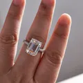 Détail macro de bague moissanite taille émeraude avec serti pavé sur anneau argenté - Taille 5 / Taille émeraude / Argent