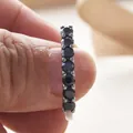 S925 sterling silver band ring featuring seven round-cut black gemstones in a prong setting - US 5 / Black