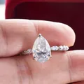 Macro shot of a 4-carat pear-cut moissanite ring with marquise side stones in S925 silver - US5 / 4 Carat D Color (Silver)