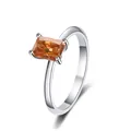 Macro view of radiant emerald cut orange moissanite gemstone set in a silver ring - Champagne