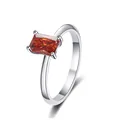 Macro detail of rectangle-cut orange-red moissanite ring in polished silver setting - Watermelon red