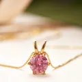 Primer plano de piedra moissanita rosa engastada en oro en una fina cadena dorada - Moissanita Rosa / Dorado
