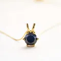 Elegante collar de oro con un gran zafiro azul oscuro de talla redonda y engaste de seis garras - Moissanita Negra / Dorado