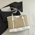 Stroh-Stofftasche mit weißem Lederbesatz und Modelabel auf strukturiertem Hintergrund - Weiß