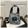 Gros plan sur la broderie jacquard florale du sac seau bleu et blanc avec anses tissées - Modèle 5