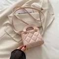 Rosafarbene gesteppte Umhängetasche mit goldener Hardware auf einem beigen Blazer - Rosa
