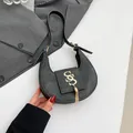 Elegante bolso medialuna gris oscuro con flecos dorados y logo metálico chic - Negro