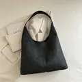 Large black minimalist hobo tote bag with matte texture and wide shoulder strap - Black