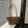 Classic brown PU leather tote bag with long handles shown in a modern home interior - Brown