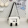 Minimalist cream canvas crossbody bag with black straps and utility pockets - White