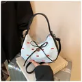 Détail du sac demi-lune blanc à pois rouges, bordure en cuir noir et pendentif cœur - Style à Nœud Pois Rouge Blanc (Vert)
