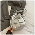 Silver metallic mini backpack for women featuring a large decorative bow and slim straps - Silver