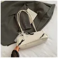 Chic off-white baguette bag with black bows and pearl charm for 2025 summer commute - White With Pendant