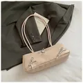 Chic beige baguette shoulder bag with stylish bow accents on a charcoal blazer background - Pink Without Pendant