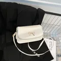 Bolso bandolera de cuero blanco con hebilla de lazo dorado estilo moderno - Blanco