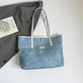 Elegante borsa tote azzurra texture denim con manici argento e dettagli con borchie oro - Azzurro