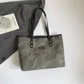 Grande borsa tote grigio verde con rivetti ed etichetta moda sulla parte frontale - grigio scuro