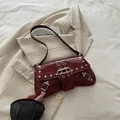 Sac baguette en cuir verni rouge foncé avec rivets argentés et boucles sur un blazer - Rouge