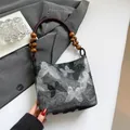 Elegante schwarze Handtasche mit Schmetterlingsstickerei und dunklen Holzperlengriffen - Schmetterling Stil Silber