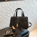 Elegant black crocodile texture handbag with shimmering finish and gold clasp closure - Black