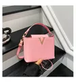 Pink woven leather crossbody handbag featuring a prominent gold V-shaped metal clasp - Pink
