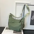 Borsa a mezzaluna in nylon verde erba con tracolla larga e dettagli zip intrecciati - Verde