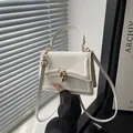 Minimalistische weiße Damenhandtasche aus Leder mit goldenen Beschlägen und Schultergurt - Weiß