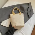 Große Stroh-Einkaufstasche in Naturbelassen mit leuchtend gelben Stoffgriffen und Gurten - Beige