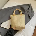 Schicke hellbeige Stroh-Tragetasche mit Fischgrätmuster auf einem lässigen Blazer - Khaki