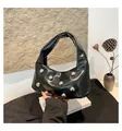 Close-up of black glossy leather moon bag featuring large silver sphere rivet details - Black