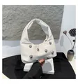 Detail of white PU leather crescent bag with silver metallic studs on a white gift box - White
