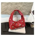 Close-up of red patent leather shoulder bag with decorative silver spherical studs - Red