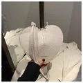 Detailed macro of white heart-shaped bag with embossed crocodile texture and zipper - White