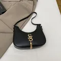 Schwarze Halbmond-Tasche mit goldenem Logo und langen Metallfransen-Details - Schwarz