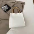 Minimalist white tote bag with beige handles on a brown blazer and magazine - White