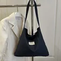 Navy blue denim tote bag with fashion label and drawstring closure in casual style - Blue