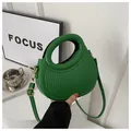 Dettaglio della borsa verde brillante con goffratura a righe verticali e manico tondo - Verde