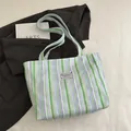 Bolso de lona con rayas verticales en verde y morado con etiqueta de moda - Verde
