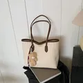 Large beige faux leather tote bag with brown trim and cute plush bear accessory - Off-white with Pendant
