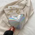 Holographic heart-shaped crossbody bag with golden chain strap on a beige blazer - Silver