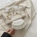 White shell-shaped mini crossbody bag with pearl chain and gold metal hardware - White