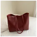 Detailed view of burgundy faux leather tote bag with vertical stitching and double handles - Red