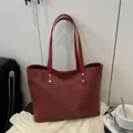 Bolso tote rojo oscuro con textura tejida y remaches plateados para el transporte diario - Rojo