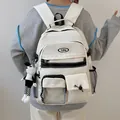 Zaino in nylon bianco minimalista con logo YuNa e ciondolo a scacchi indossato dal modello - Con Ciondolo / Bianco