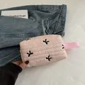 Light pink quilted makeup bag with black embroidered bows and side carry handle - Light Pink