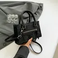 Minimalist black tote bag with ruched leather texture and silver zipper details - Black