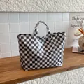 Dettaglio della borsa tote a scacchi capiente con trama in PVC lucido e impermeabile - Quadri bianco e nero